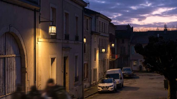 Luminaires ALUCA éclairant une rue ciel crépuscule voiture au second plan 